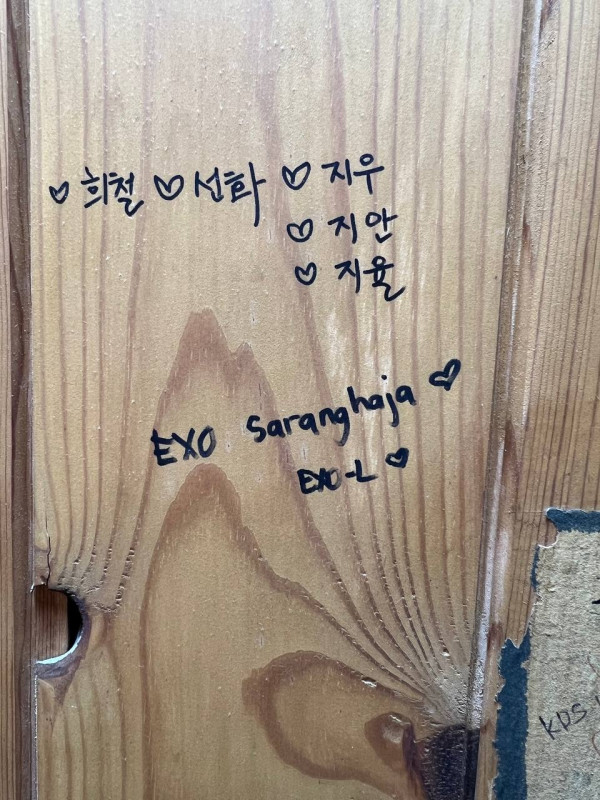 화장실 칸막이 내부의 비문